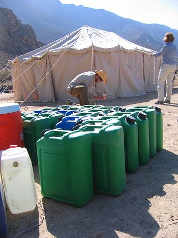 Field camp: putting up the Bedu tent and water cannisters (courtesy of Claudia Hosp).
