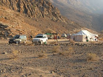 Field camp (Land Rovers, Bedu mess and communal tent and dome sleeping tents in the background).